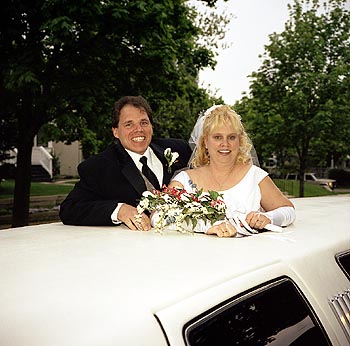Couple standing up through limo sunroof